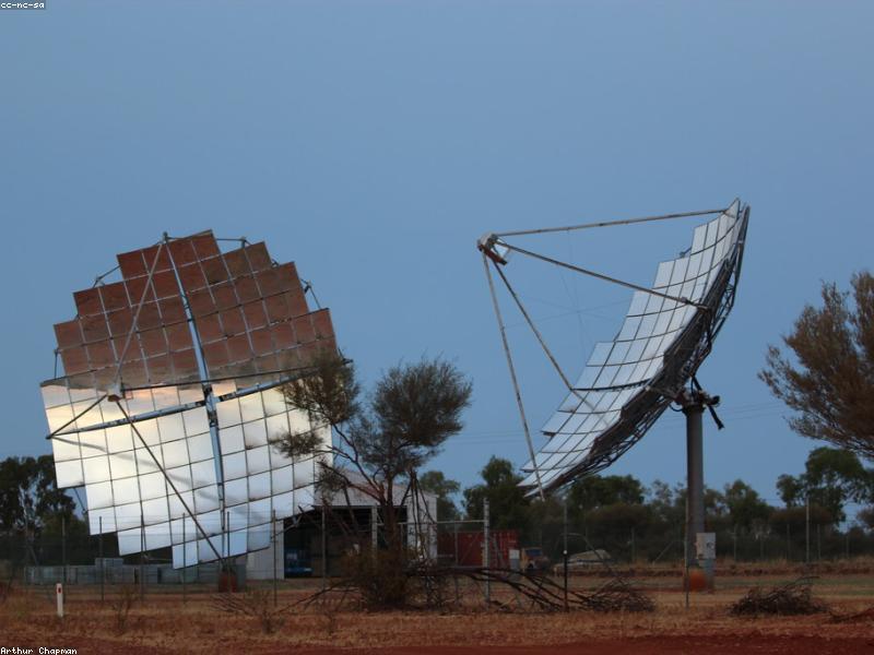 Vast field of solar panels under a bright sun and blue sky