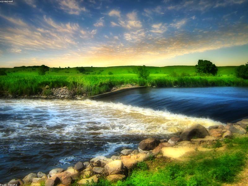 Large concrete dam with water flowing through spillways