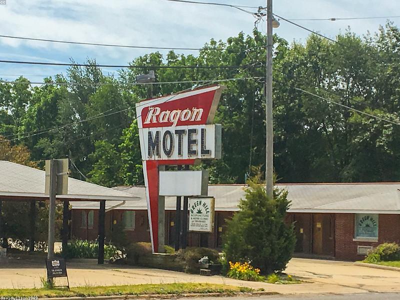 A classic American motel with neon sign and vintage cars