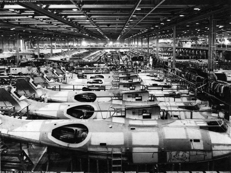 Workers assembling an aircraft in a large hangar