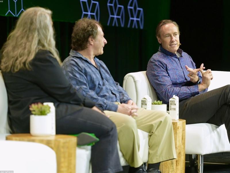 Person speaking on stage with audience in background