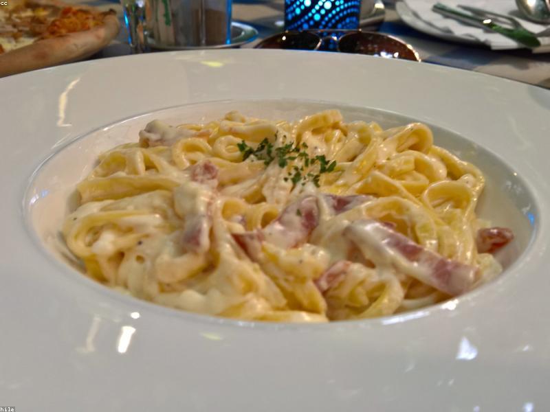 A bowl of creamy carbonara pasta with crispy pancetta bits and fresh black pepper