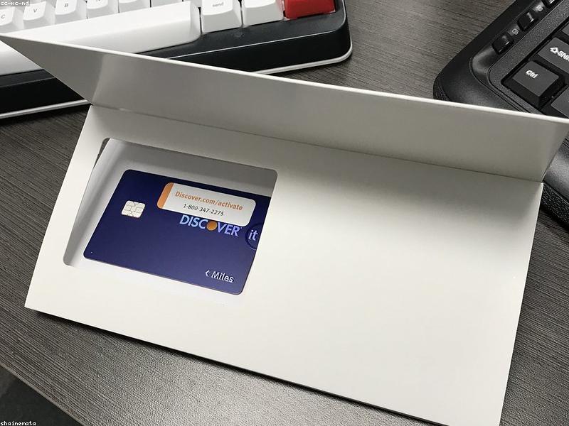 A person holding a smartphone displaying a credit score graph with a credit card nearby